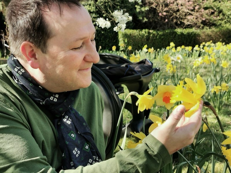 Mark Lane in a garden surrounded by daffodils