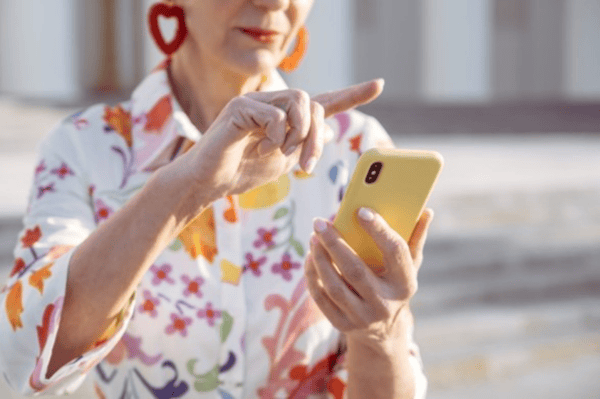 A female holding a yellow mobile phone