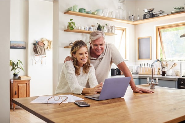 Older couple researching online using a laptop at home